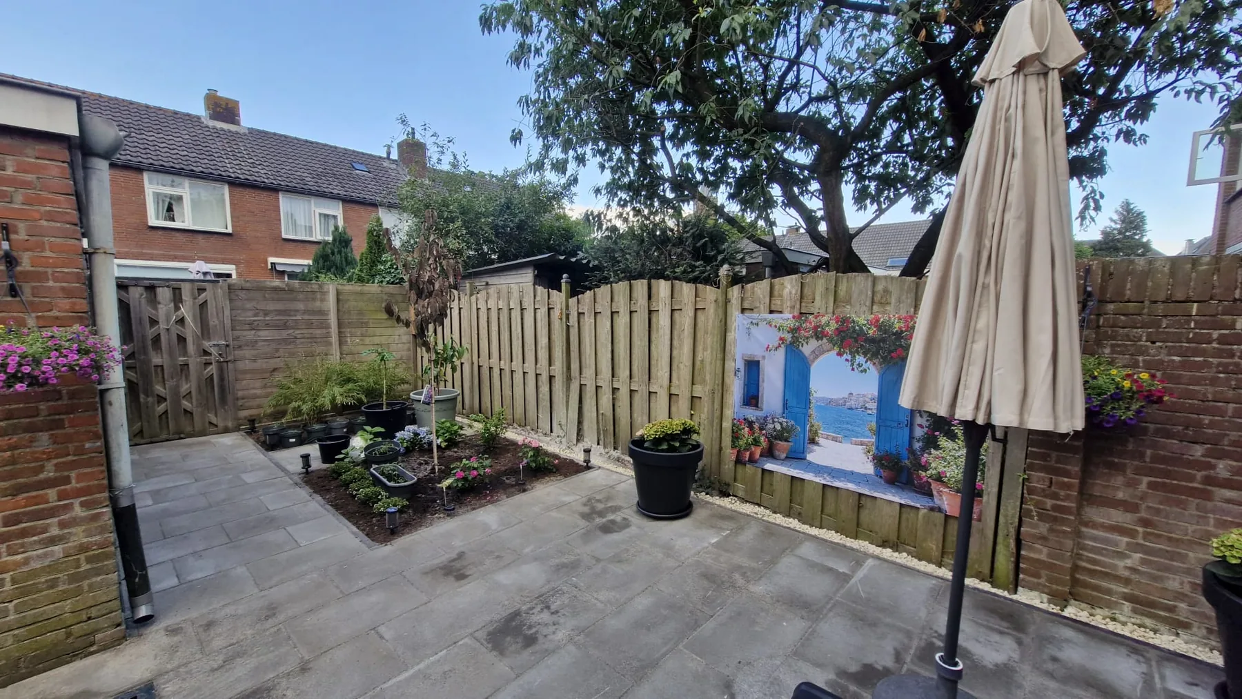 Tuin met erfafscheiding, groen en bestrating
